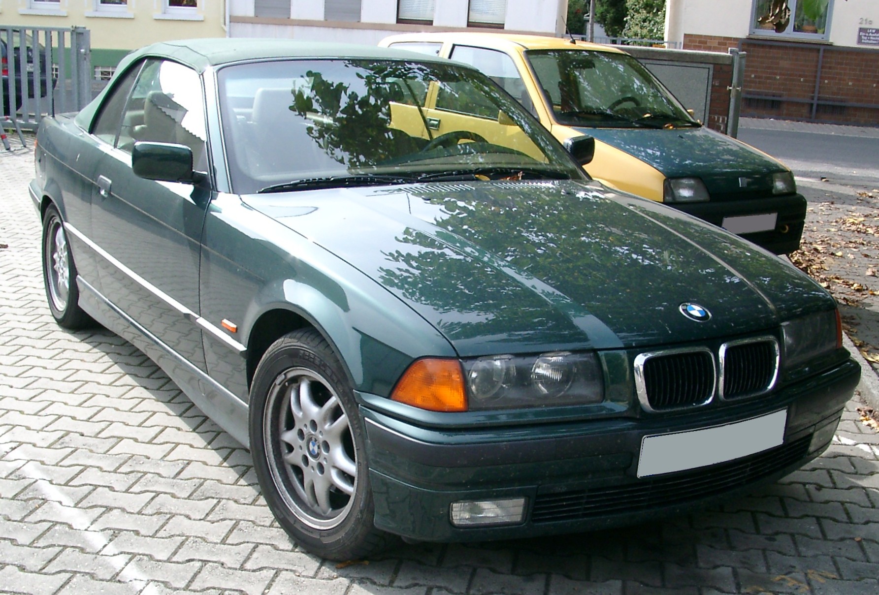 BMW E36 320i Cabrio in Dunkelgrün mit geschlossenem Verdeck, Frontansicht