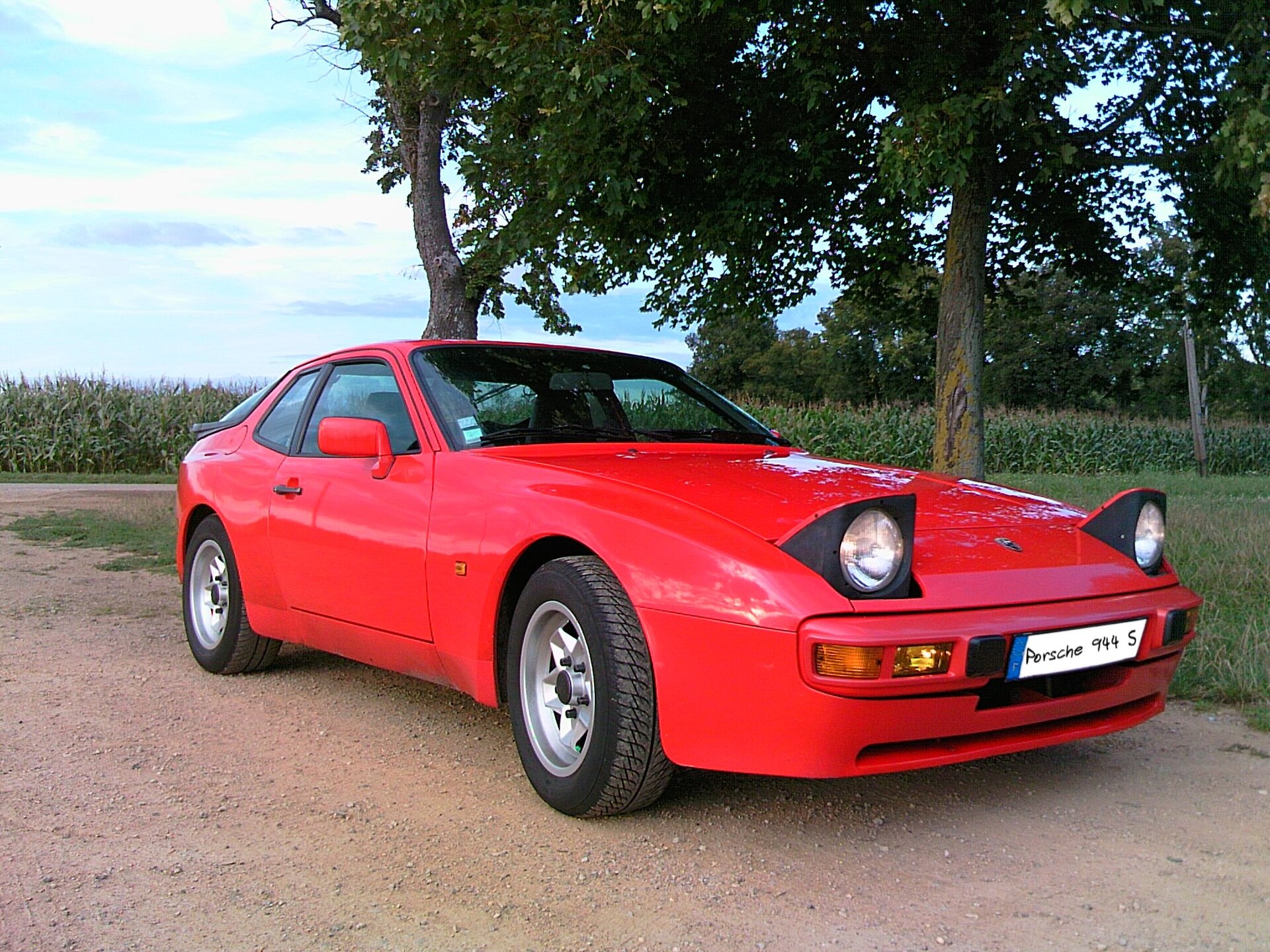 Roter Porsche 944 S mit schmaler Karosserie und Klappscheinwerfern, 3/4-Frontansicht