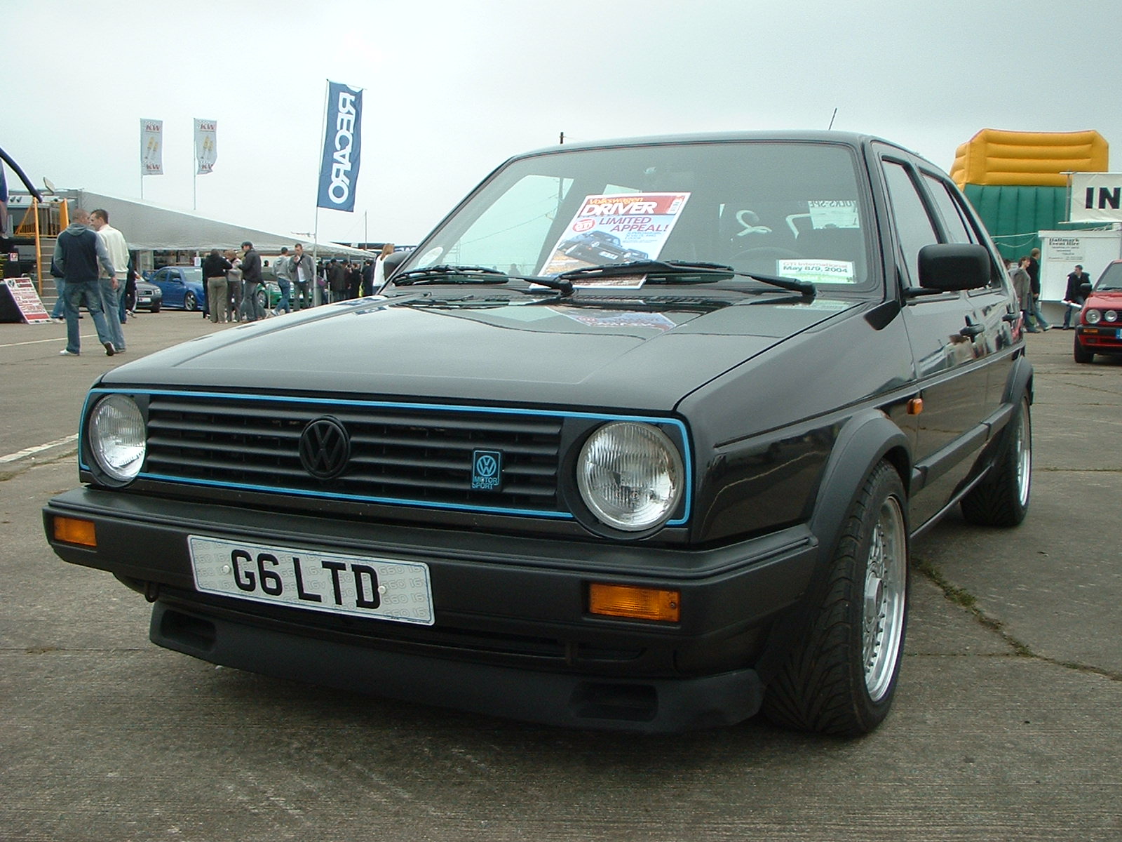 Schwarzer VW Golf 2 G60 mit G60-Emblem am Grill, blauer Zierleiste und Doppelscheinwerfern